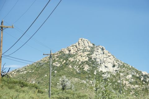 1995 Ford Taurus - A mountain landscape is visible under a clear blue sky, with telephone poles and wires crossing the frame.