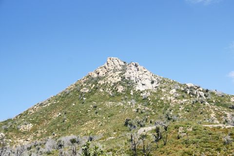 1995 Ford Taurus - A mountain peak dominates the landscape, with sparse vegetation clinging to its rocky slopes.