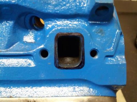 1997 Ford Ranger - Close-up view of a blue engine block part, likely an intake manifold or cylinder head, showing a rectangular port and bolt holes.