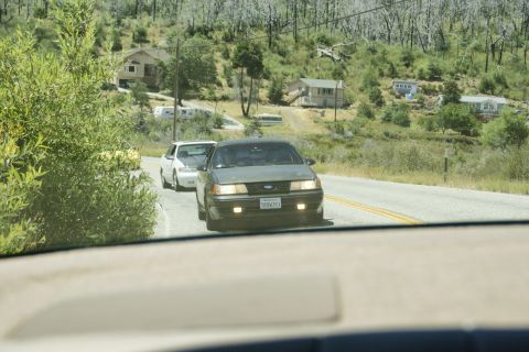1995 Ford Taurus - A 1995 Ford Taurus is seen driving on a road with another vehicle behind it.