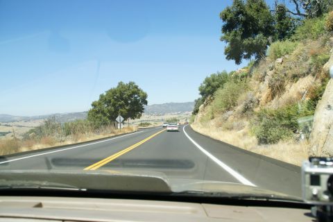 1995 Ford Taurus - Driving on a sunny day on a two-lane highway through a hilly, arid landscape.