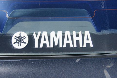 1995 Ford Taurus - A Yamaha sticker is affixed to the rear window of a dark blue vehicle.