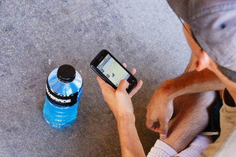 1995 Ford Taurus - Person checks phone next to a Powerade bottle on a textured surface.