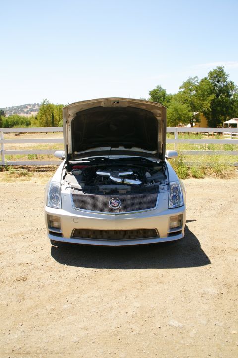 1995 Ford Taurus - This silver Cadillac is viewed from the front with its hood open, revealing the engine compartment.