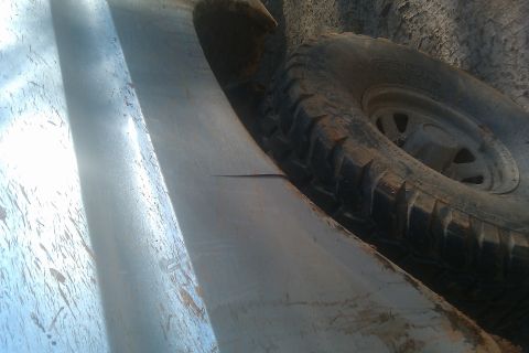 1978 Ford Bronco - A close-up view shows the fender and a tire of a vehicle, with visible mud and dirt.