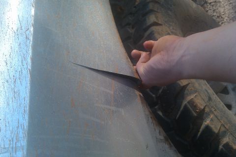 1978 Ford Bronco - A hand holds a knife against a tire and metal panel, with "SuperMotors.net" visible at the bottom right.