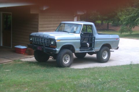1978 Ford Bronco - A silver 1978 Ford Bronco is parked in front of a house with its doors removed.