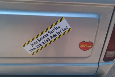 1978 Ford Bronco - Stickers on a silver vehicle's rear panel include 'Jeep Rescue Service' and a 'HOOKER' heart.