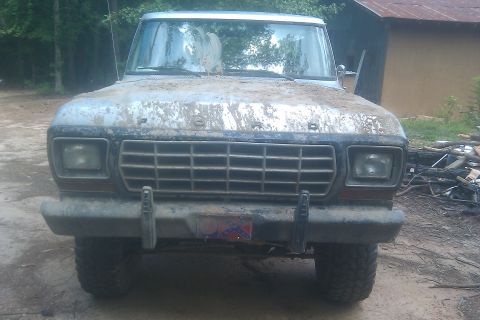 1978 Ford Bronco - This muddy 1978 Ford Bronco is seen from the front, with its grille and headlights partially obscured by dirt.