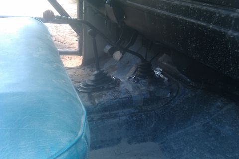 1978 Ford Bronco - Interior view of a vehicle's floor with two gear shifters and a blue seat visible.
