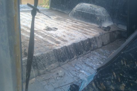 1978 Ford Bronco - The interior of a truck bed shows a muddy floor and a floor shifter, suggesting it has seen heavy use.