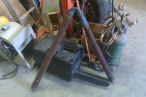 1978 Ford Bronco - Welding equipment and metal pipes are arranged in a workshop setting, with a toolbox and oxygen tank visible.