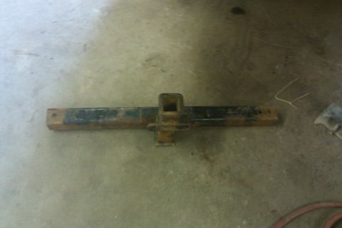 1978 Ford Bronco - A rusted trailer hitch receiver part lies on a concrete surface.
