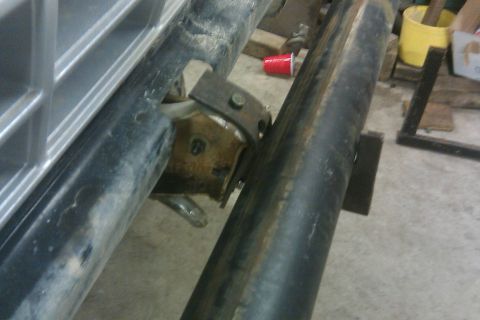 1978 Ford Bronco - A close-up view of the vehicle's frame and bumper mounting hardware, showing signs of wear and rust.