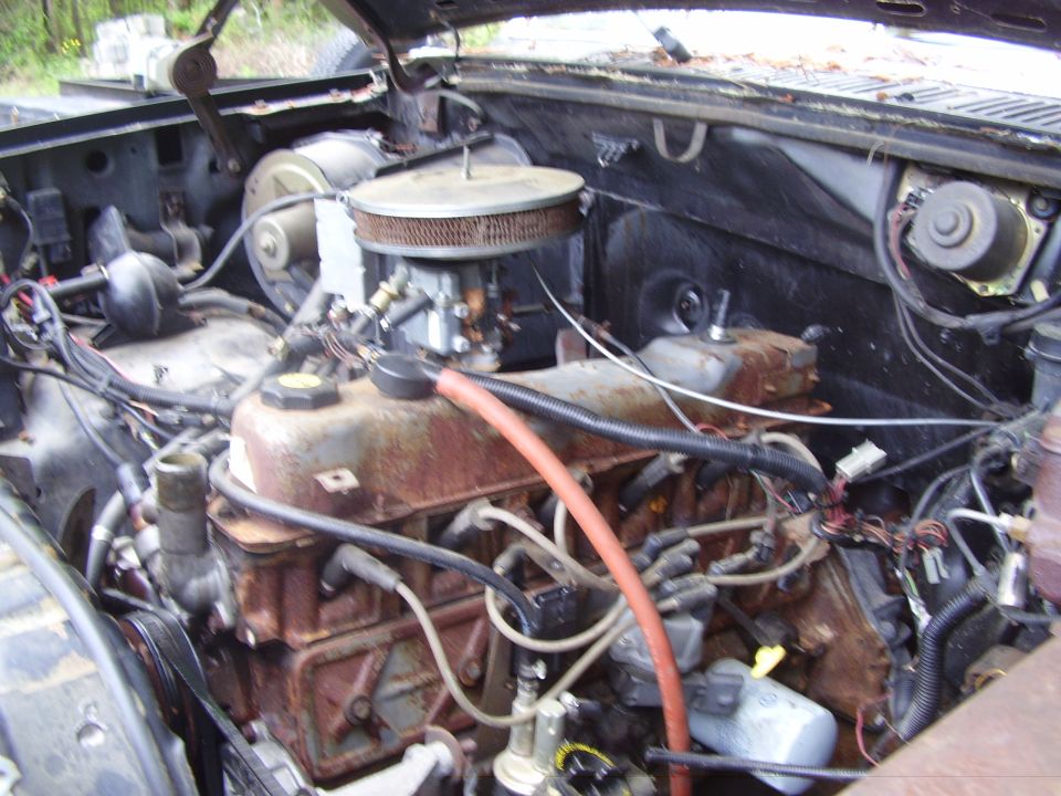 engine bay with carburetor and rusty engine block