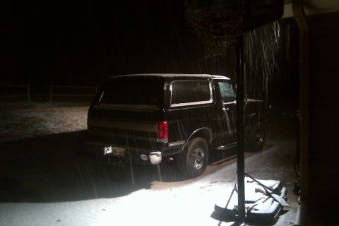 1988 Ford Bronco - A black 1988 Ford Bronco is seen parked in the snow at night.