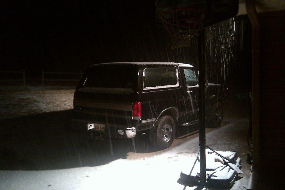Black 1988 Ford Bronco in snow, rear view