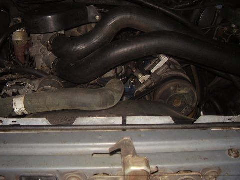 1988 Ford Bronco - Close-up view of an engine bay, showing various hoses and mechanical parts.