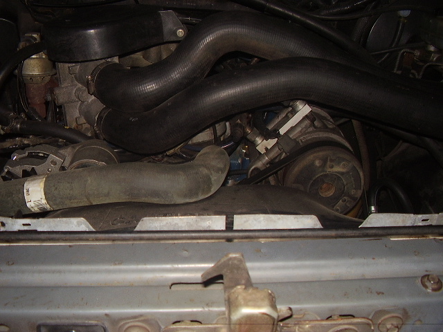 Engine bay with hoses and engine components visible. A Supermotors.net watermark is present