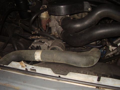 1988 Ford Bronco - Close-up view of an engine bay, focusing on hoses and the alternator.