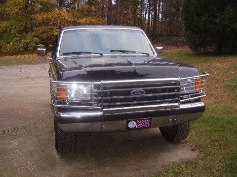 1988 Ford Bronco - This Ford truck features a prominent chrome grille and bumper, with a distinctive license plate.