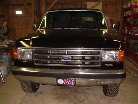 1988 Ford Bronco - Front view of a black Ford Bronco, likely from the late 1980s, parked indoors.