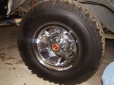 1988 Ford Bronco - Close-up of a chrome wheel and BFGoodrich tire, a red and gold center cap.