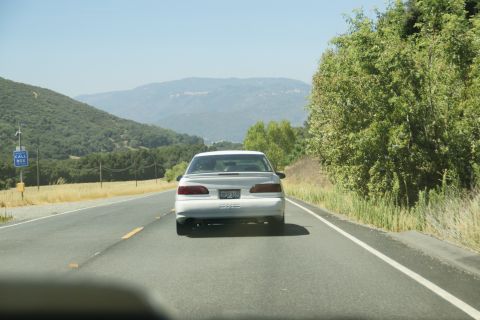 1995 Ford Taurus - Rear view of a white 1995 Ford Taurus driving on a highway.