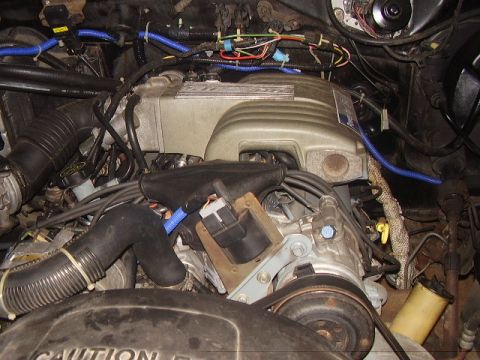 1986 Ford Bronco - Close-up view of an engine bay, showing various components and wiring. The image includes a watermark for SUPERMOTORS.NET.