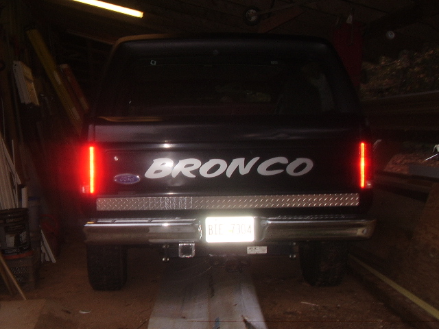 Black 1986 Ford Bronco rear view with 'BRONCO' text and diamond plate trim