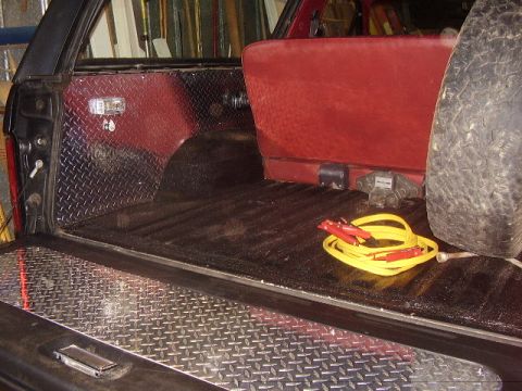 1986 Ford Bronco - The cargo area of this 1986 Ford Bronco features diamond plate lining and red seating.