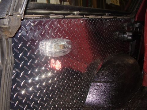 1986 Ford Bronco - Interior view of a vehicle's side panel and wheel well, modified with diamond plate.