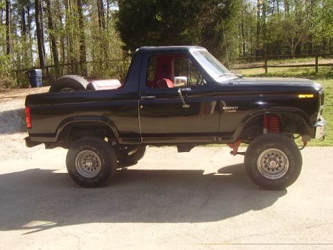 1986 Ford Bronco - This black 1986 Ford Bronco features a lifted suspension, red interior, and a spare tire mounted on the rear.