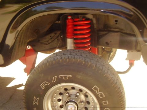 1986 Ford Bronco - Close-up of the front suspension and tire on a 1986 Ford Bronco.