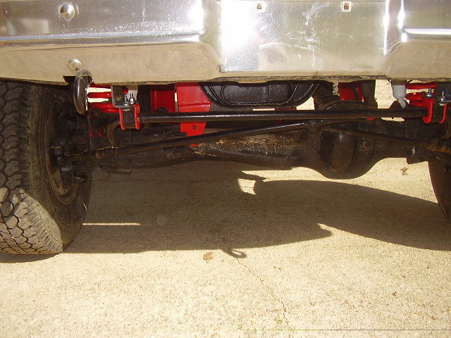 Undercarriage view showing suspension and differential components. Chrome bumper visible above