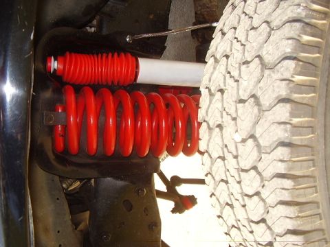1986 Ford Bronco - Close-up view of suspension components and a tire, with visible text from Supermotors.net.