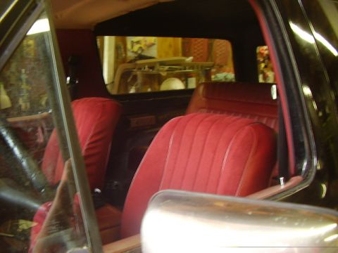 1986 Ford Bronco - Interior view of a vintage SUV with red velour seats and dark trim.