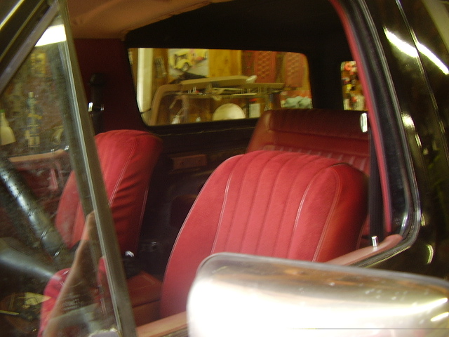 Red velour seats and interior trim of an older SUV, possibly a Ford Bronco