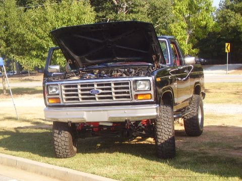 1986 Ford Bronco - Front view of a 1986 Ford Bronco, hood raised to show the engine compartment.