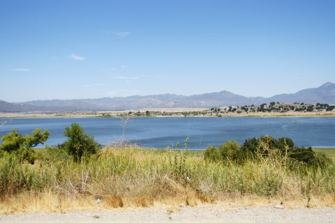 1995 Ford Taurus - A scenic view of a large blue lake surrounded by hills and mountains under a clear sky.
