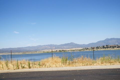 1995 Ford Taurus - A scenic view of a lake bordered by mountains under a clear blue sky.