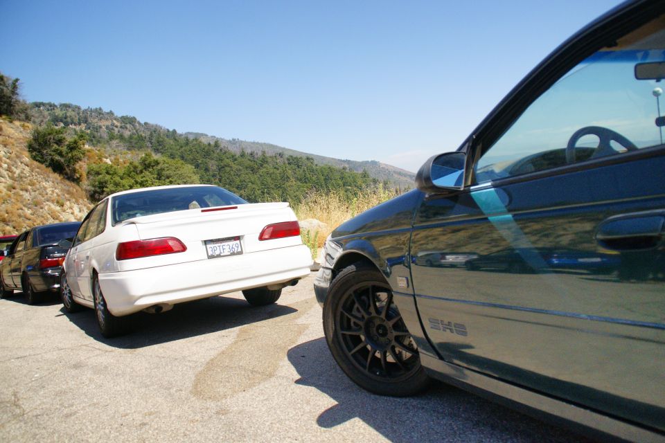 White 1995 Ford Taurus rear view, parked on a roadside with other cars behind it