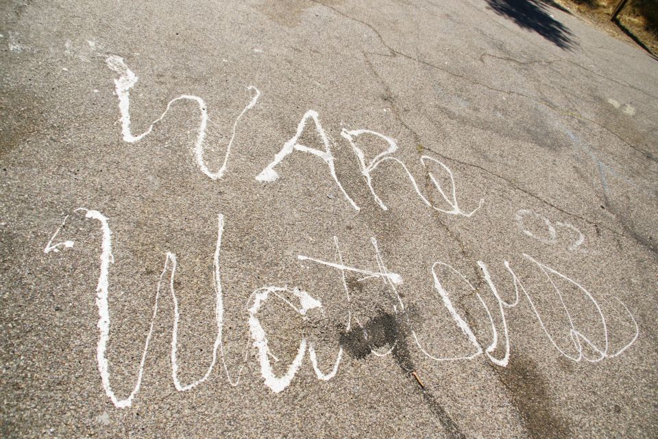 Chalk writing on asphalt says "Ware Watcn"