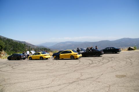 1995 Ford Taurus - Multiple cars gathered in a scenic overlook area with mountains in the distance.