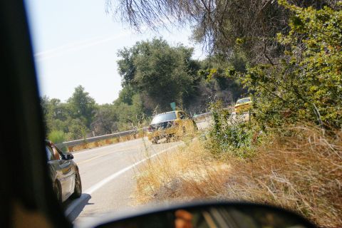 1995 Ford Taurus - A yellow sedan is seen driving on a winding road, with another yellow vehicle visible in the distance.