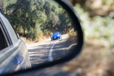 1995 Ford Taurus - Driving on a rural road, a blue sports car is visible in the side mirror.