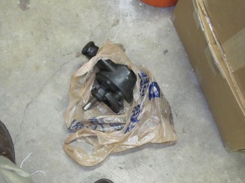 1995 Ford Bronco - A power steering pump sits in a plastic bag on a concrete floor next to a cardboard box.