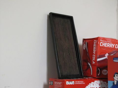 1995 Ford Bronco - An air filter rests on boxes of Big K Cherry Cola next to a white wall.