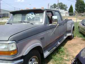 1995 Ford Bronco - A three-quarter front view of a gray and blue Ford F-350 Super Duty pickup truck parked outdoors.