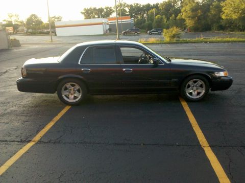 1999 Mercury Grand Marquis - Side profile of a black Mercury Grand Marquis sedan parked in a parking lot.